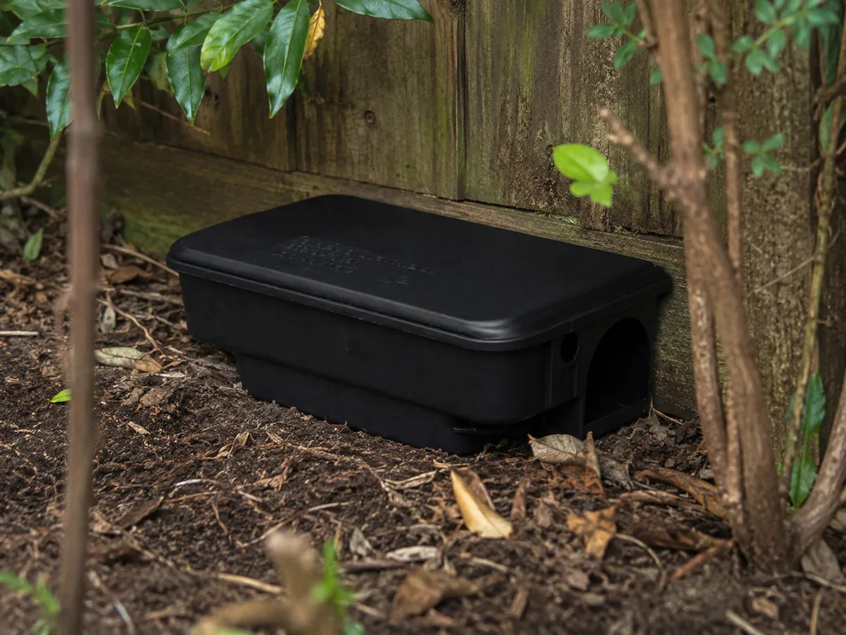 Portacebos de seguretat tancat instal·lat en jardí al costat d’una tanca perimetral